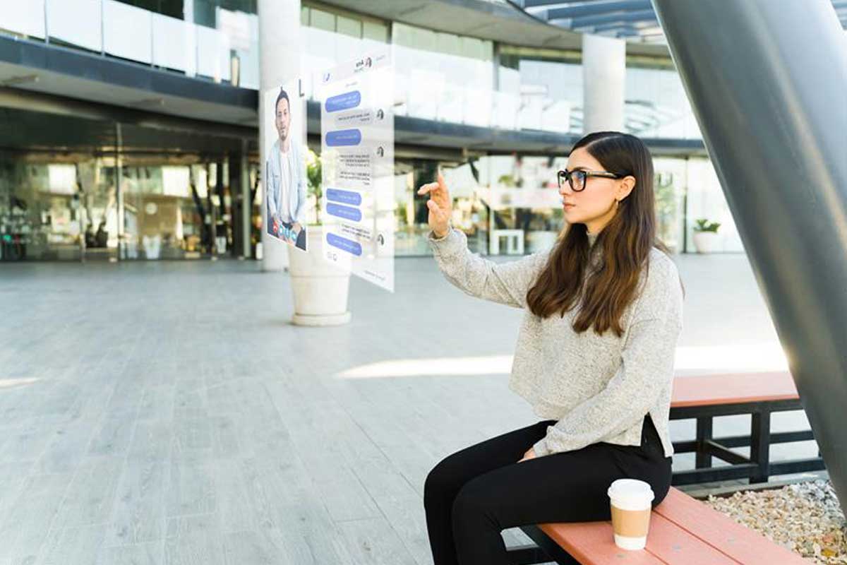 Smart-Glasses-are-Going-Next-Gen-with-AI Blog---Woman-sitting-down-wearing-AR-Glasses